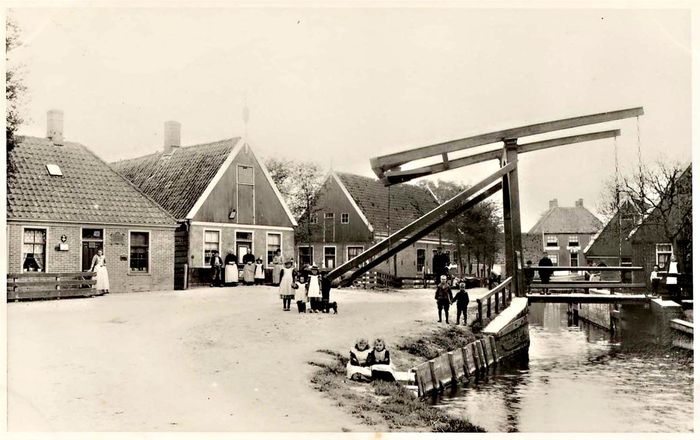 Foto 1: De Niedorper schutsluis met brug uit 1915 
Voordat de Grote Waard in 1631 droogviel, waren er twee mogelijkheden om met de boot op dat meer te komen. Via een overtoom of overhaal of via een schutsluis. Een overhaal was een op een dijk geplaatste lier met aan weerszijden een schuine helling. Hiermee werden boten met en kabel over de dijk getrokken. Ze stonden op verschillende plaatsen rondom de Waard. Een schutsluis was aanvankelijk een houten constructie, later van baksteen, waar je met een boot invoer en na het openen van de sluisdeuren het meer op kon varen. Er was er een bij Noord Scharwoude en een bij Oude Niedorp. Zo’n schutsluis werd indertijd ‘verlaat’ genoemd. En nog steeds heet de plaats waar de sluis van Oude Niedorp heeft gelegen het Verlaat.  
